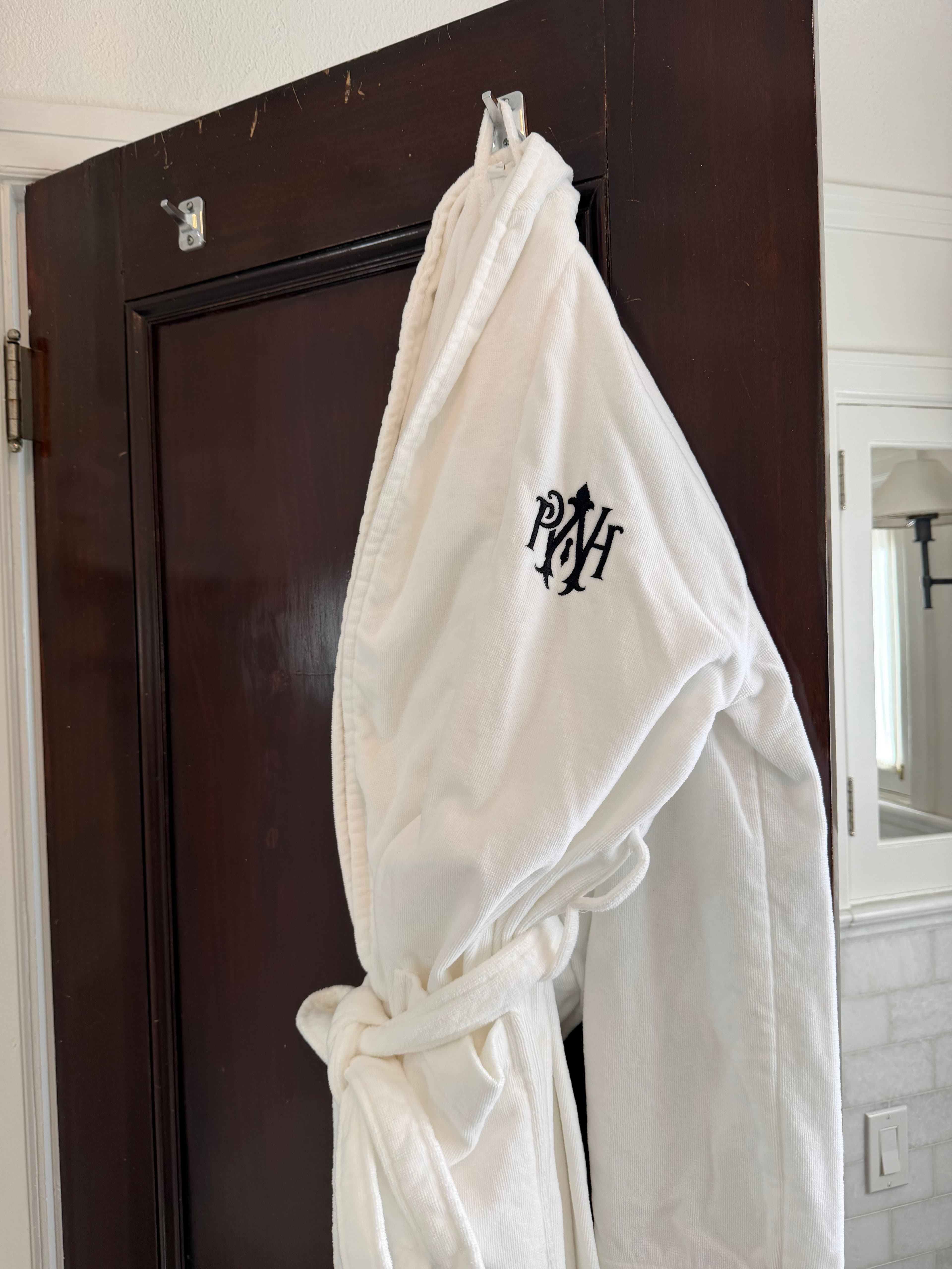 Monogrammed house robe hanging in a guest bath