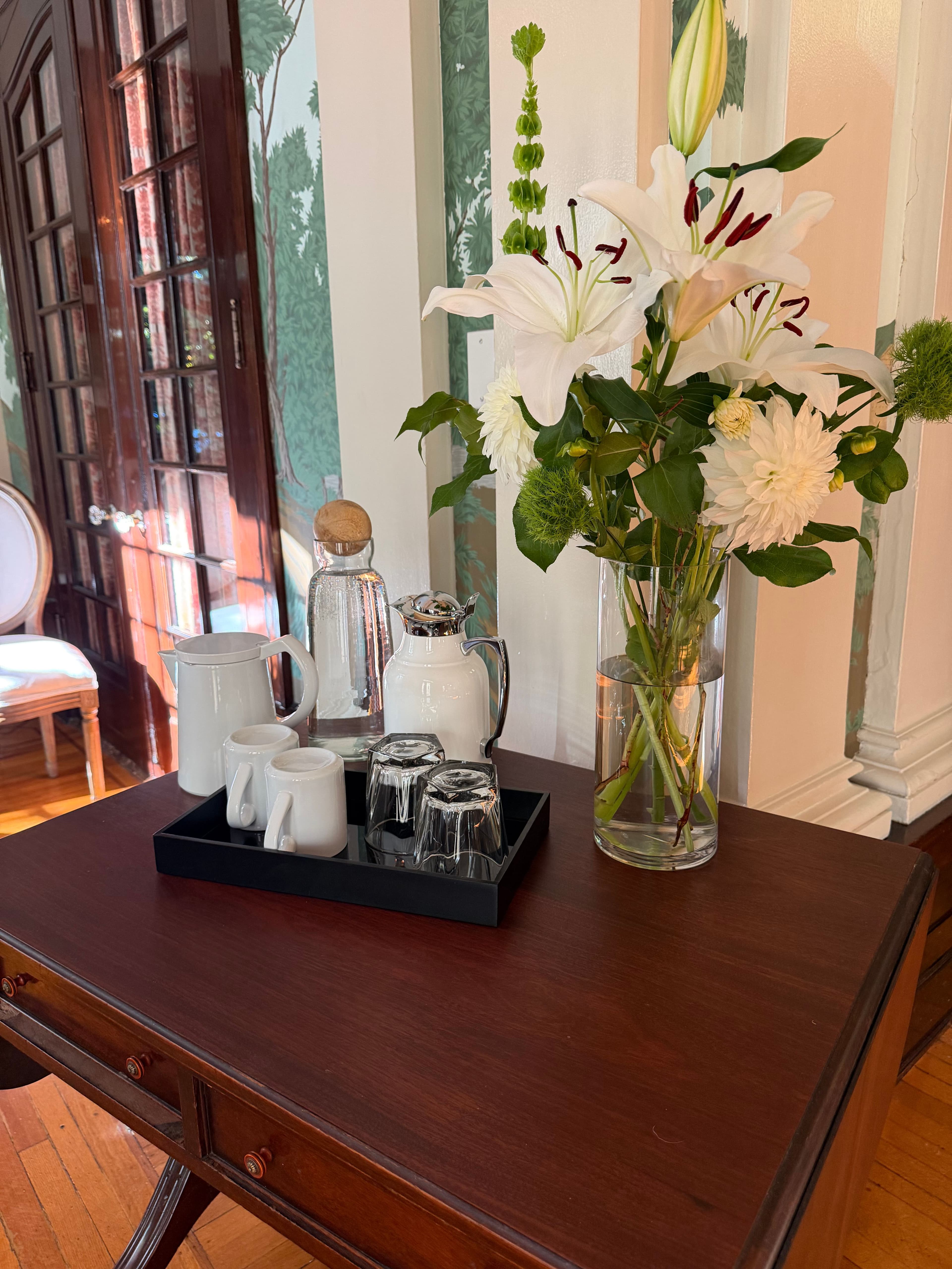Coffee tray and fresh lilies beside the hand-painted parlor walls