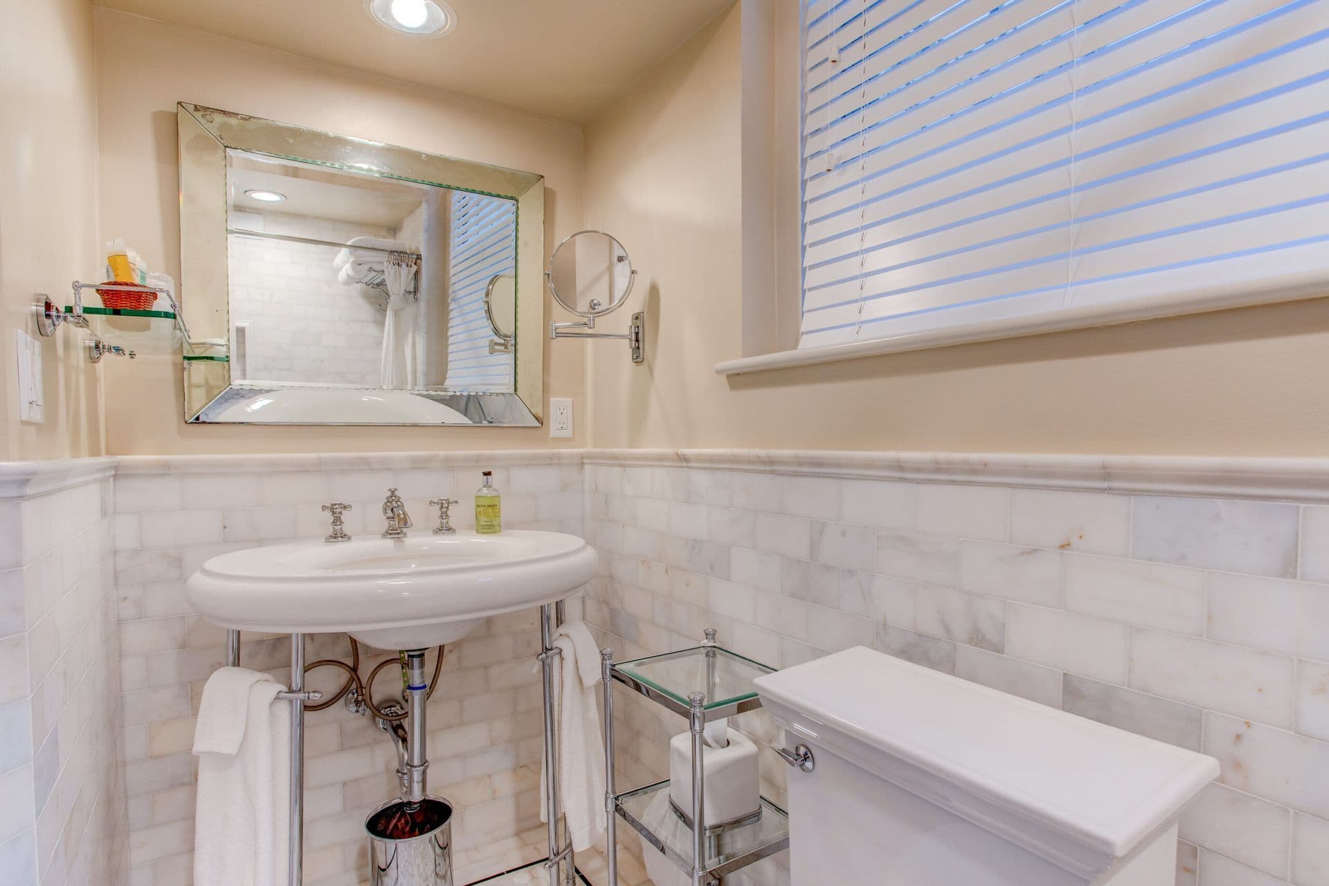 Bathroom with a sink, toilet, mirror and window